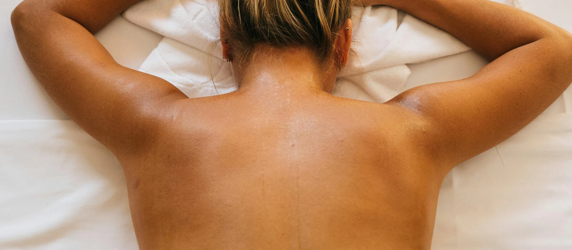 Therapist working across a client's back during a massage appointment at Mind and Body Holistic Healing.